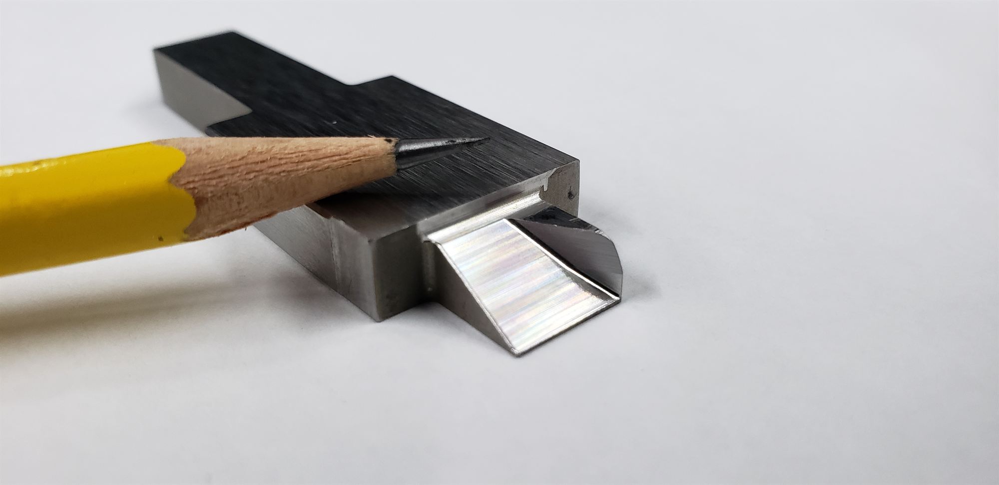 Very small machined feature shown next to a pencil